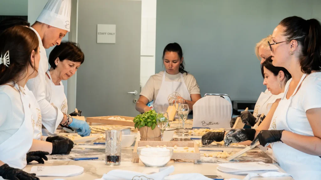 margherita_cooking_class-shoot_01-orizzontale-55 Partecipanti alla Margherita Cooking Class preparano gnocchi fatti a mano sotto la guida dello chef durante un corso di cucina a Baveno sul Lago Maggiore.