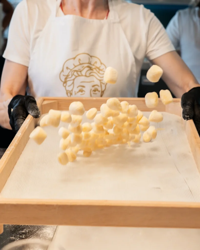 margherita_cooking_class-shoot_01-verticale-51 Durante Margherita cooking class a Baveno sul lago Maggiore sta facendo saltare gnocchi in preparazione