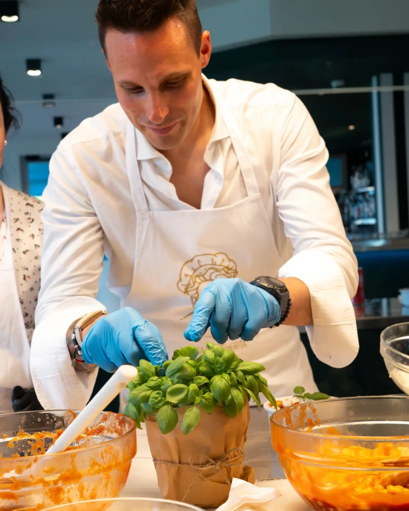 margherita_cooking_class-shoot_01-verticale-63 Durante Margherita cooking class a Baveno sul lago Maggiore un signore prepara basilico